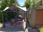 Outdoor dining with patio table and chairs for four under canopy, barbecue with propane provided